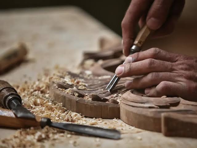 Artesano trabajando la talla en madera en un taller de arte sacro